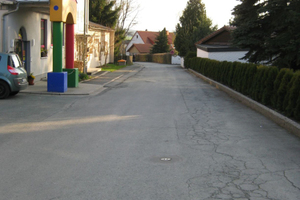  Die Schulstraße in Issigau im Jahre 2010 vor ihrer Sanierung mit rissigem Asphaltbelag und ohne ausgewiesenen Platz für Fußgänger.  