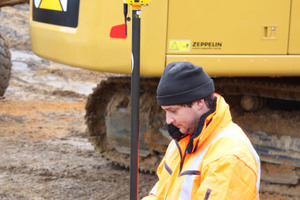  Polier Josef Heigl kontrolliert mit dem GPS-Roverstab den Abtrag der Höhen und Neigungen. 