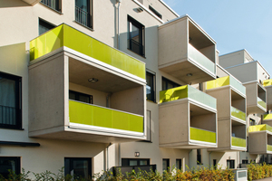  Ein besonderes Merkmal der Fassade sind die vor Ort aus Beton hergestellten Balkone mit grün eingefärbter Glasbrüstung, die wie Rahmen auf die Fassade gesetzt sind. 