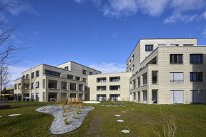  Die fünf gestaffelten Baukörper fassen einen gemeinschaftlich genutzten Innenhof mit Grünanlage und Spielplatz ein. 