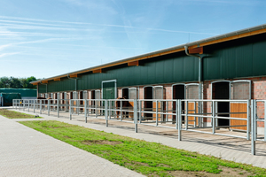  Zur Gestaltung der Fassade wurden Ziegelmauerwerk und Isowandprofile kombiniert. Sie geben der Reithalle und den Stallungen ein modernes Erscheinungsbild und nähern sich dem historischen Klinker des Altbestandes an. 