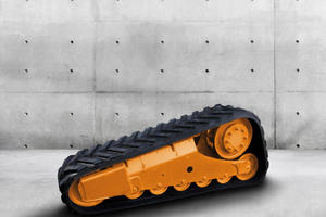  Das neue Fahrwerksystem für Kompakt-Raupenlader zeichnet sich durch eine Antriebskette mit gummierten Antriebsstollen aus.  