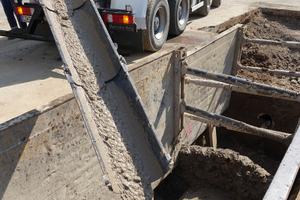  Der Flüssigboden wird in Transportmischern auf der Baustelle angeliefert und über eine Rutsche in den Rohrgraben eingefüllt. 