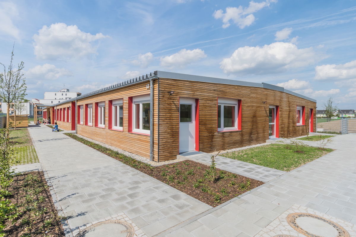 Mit einer hochwertigen Fassade sowie den farblich abgesetzten Fenster- und Türlaibungen gibt sich das neue Kinderhaus nach außen nicht als Containerbauwerk zu erkennen.