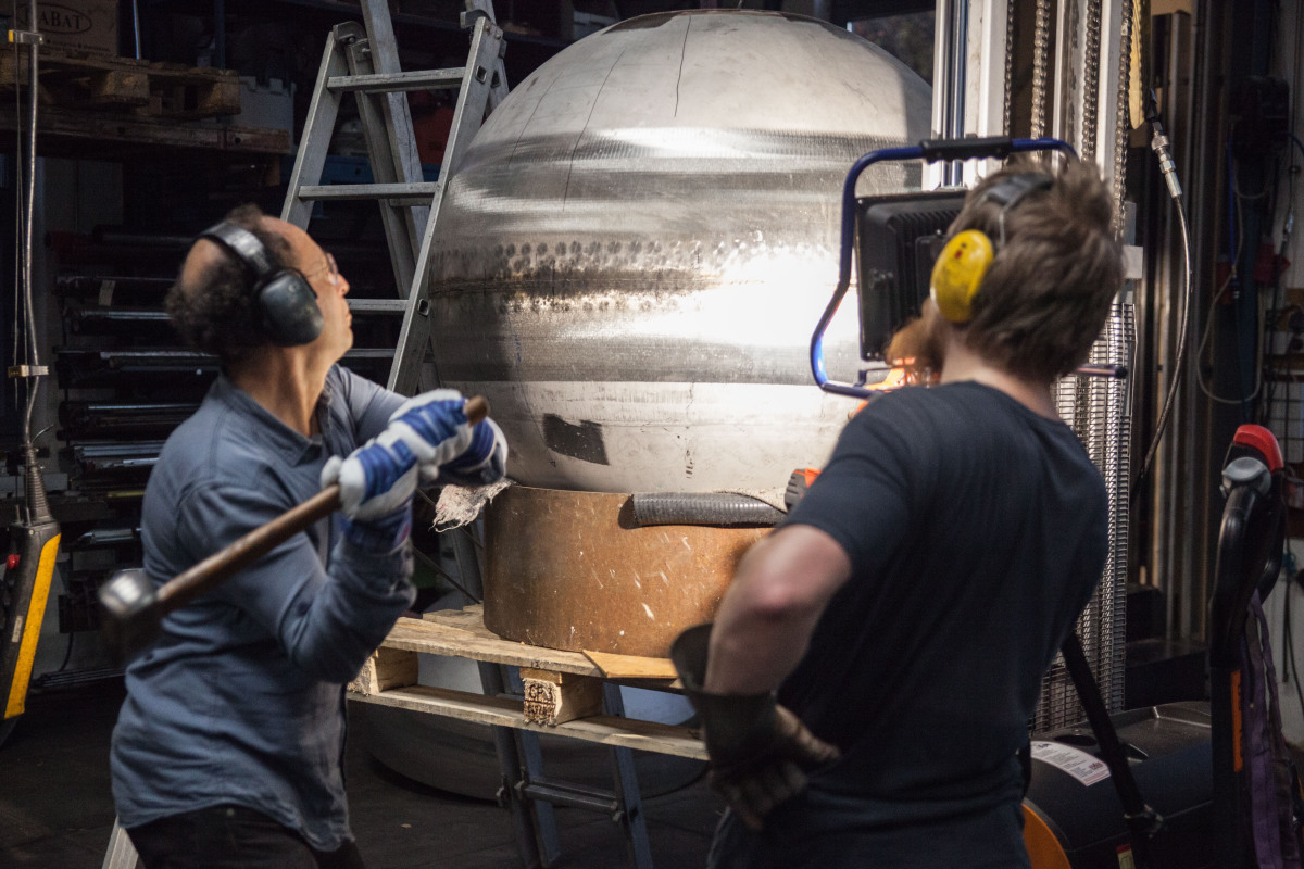 Herstellen der Kugeldüsen im Metallatelier. Vor dem Rundschleifen erfolgt noch manuelles Feinjustieren der Kugelform mit dem 3-kg-Hammer.