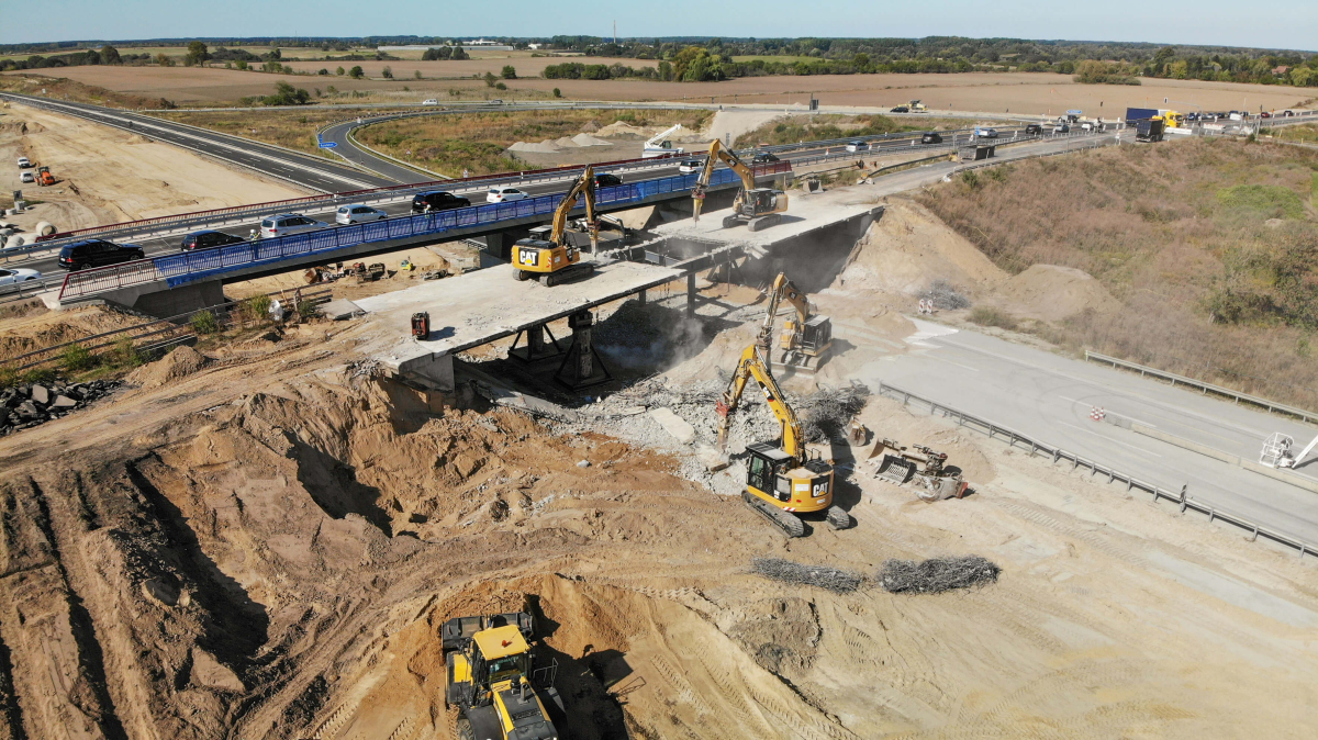 Zwei Kettenbagger befinden sich auf der Brücke, mit hydraulischer Abbruchschere und Abbruchhammer. Zwei weitere Bagger nehmen sich am Boden der abgebrochenen Teile an.