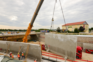  Die Anschlussbewehrung an der Unterseite der Stützwandelemente wird mit der Bewehrung im vorgefertigten Fundament vergossen. Dieser Arbeitsschritt erfolgt nach dem Versetzen und Fixieren der Wandelemente und vor dem Verfüllen des Arbeitsraumes. 