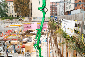  Aus der Autobetonpumpe von Heidelberger Beton wird der Baustoff zur Rohrleitung im    Untergeschoss transportiert. 