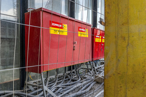  Insgesamt stehen 38 der roten Stromverteilerkästen auf dem Baufeld in Köln. 