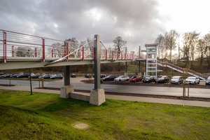  Über eine Treppe und einen Aufzug ist die Brücke an den darunterliegenden Bahnhof mit P+R-Parkplatz angebunden. 