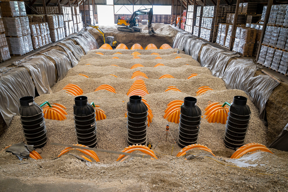 Unter der alten Salzlagerhalle im neuen Gewerbegebiet Meitingen werden die Birco Rigolentunnel von Stormtech installiert. Trotz sehr beengter Baustellenverhältnisse gehen die Arbeiten zügig voran. Zu sehen sind die mittig angeordneten Kontrollschächte und