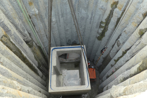  Einsetzen des ersten Stahlbetonfertigteils in den etwa 11 Meter tiefen Schacht.  