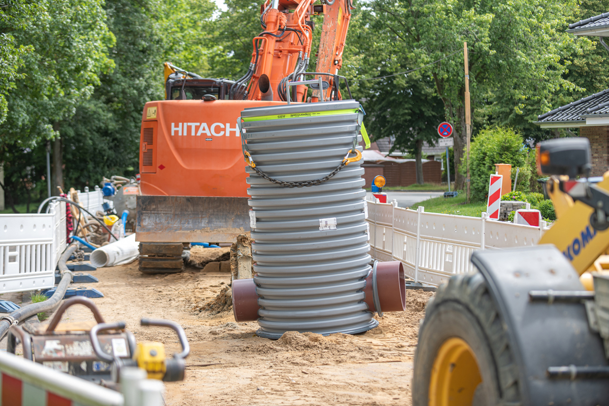 Die Sonderkonstruktion des Funke Schachtes DN 1000 mit dem kreisrunden (l.) und dem Eiprofil-Rohrspitzende (r.) steht in der Jorker Straße zum Einbau bereit.