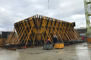  Die 60 Zentimeter starken schrägen Leichtbetonwände des Erdgeschosses, die innen glatt, nach außen aber abgestuft sind und hier die für das Gebäude charakteristische Holzstruktur aufweisen, wurden mit Sonderschalungselementen von Ulma erstellt. 