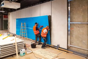  Auf den in die Unterkonstruktion eingehängten Stahlrahmenelementen werden die Glasscheiben verklebt, die hier noch mit blauer Schutzfolie belegt sind. 