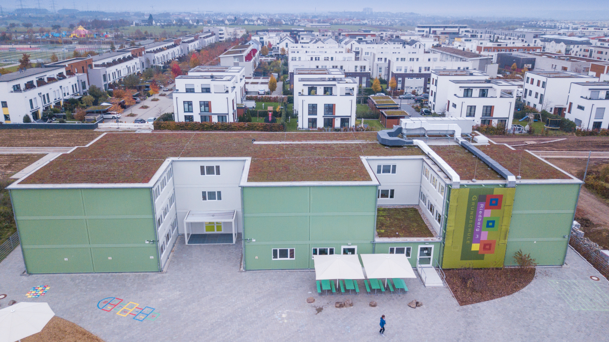 Der dreigeschossige Baukörper ist mit 2.500 m² Schulfläche ein großer temporärer Schulkomplex. Insgesamt 164 Containereinheiten wurden verbaut.