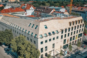  Handelsflächen besetzen die grob strukturierten unteren Ebenen, während die regelmäßig gerasterten Obergeschosse einer Hotelnutzung gewidmet sind. 