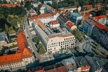 Das Hotel- und Gesch?ftsgeb?ude bildet mit seiner au?ergew?hnlichen Dachform und Fassadengestaltung einen markanten Stadtbaustein am Pasinger Marienplatz.