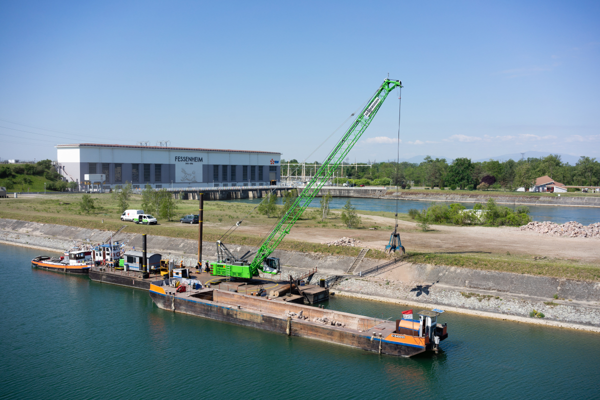 Der 655 HD, fest verbunden mit dem Ponton, bei Uferbefestigungs-Arbeiten auf dem Rhein.