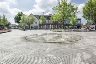 Wasserfontänen, Sitzgelegenheiten und schattenspendende Bäume erhöhen die Aufenthaltsqualität.