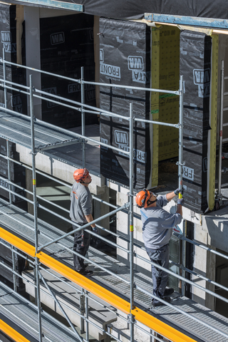 Im Gerüstbaukasten verbergen sich weitere Details, die das Arbeiten erleichtern, die Sicherheit auf der Baustelle erhöhen und die Montage oder den Abbau beschleunigen, wie zum Beispiel die vorlaufende Geländermontage im Fassadengerüst.