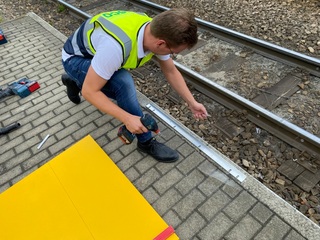 Um die Rampen der Straßenbahn zu befestigen, kommt ein verdecktes Schienensystem zum Einsatz. Bei dieser Methode wird zuerst eine U-Schiene am Boden verankert. Anschließend werden hierauf die einzelnen Rampenelemente aufgesteckt.
