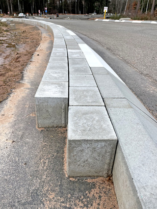 Weil Gefahr besteht, dass die Borde immer wieder durch Schwerlastverkehr an- und überfahren werden, wurde hinter den Borden eine innenliegende Pflasterung aufgebracht, die ebenso auf den Asphalt geklebt wurde.