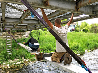 Montage der temporären Konstruktion auf der Brücke über die Reppisch. Pro Minute werden dem Gewässer kurzzeitig 400 Liter entzogen, die vom Wasserschleier zurück in den Flusslauf fallen.