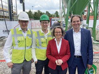 Die Vertreter von Heidelberg Materials freuen sich mit der Ministerin über das gemeinsame Projekt. (v.l.n.r.) Dr. Andreas Wiedmann (Teamleiter Innovation & Produktentwicklung) und Beda Eber (Produktmanager Betonwaren & 3D-Betondruck), Ministerin Ina Schar