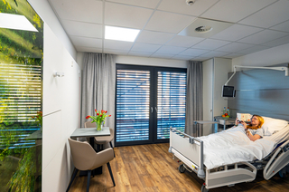 Die Patientenzimmer sind hell und freundlich eingerichtet. Bedruckte Glaswände und der Boden in Holzoptik sorgen für ein sehr wohnliches Ambiente.