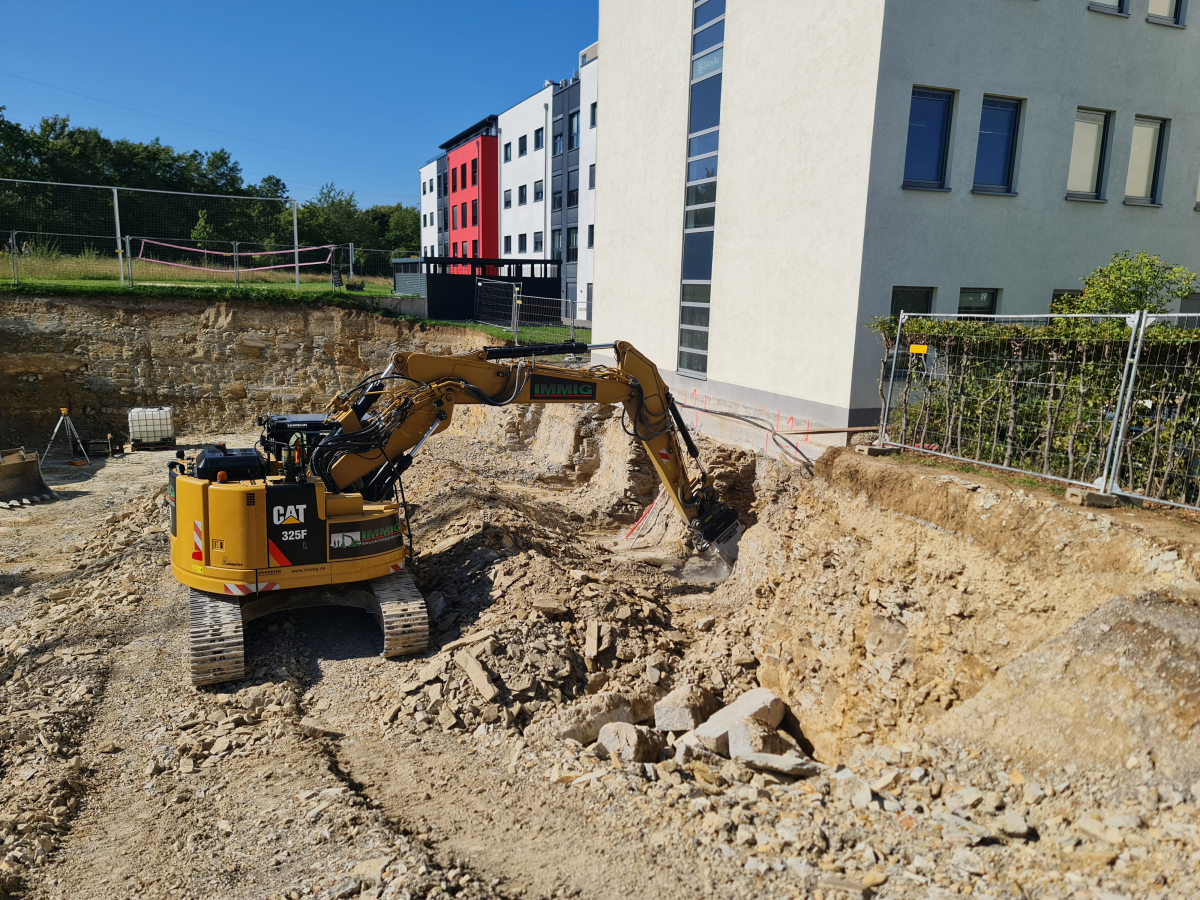 Ein 25-Tonnen-Kettenbagger und eine Querschneidkopffräse EKT 100 von Kemroc beim Unterfangen eines Gebäudes im Technologiepark von Paderborn.