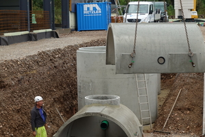  Montage der Betonfertigteile zu einem unterirdischen Sickertunnel. Im Hintergrund der Substratfilterschacht, der neben mineralölhaltigen Kohlenwasserstoffen auch Feststoffe wie Reifenabrieb und die Schwermetalle Kupfer und Zink aus dem Wasser entfernen kann 