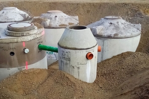  Im Vordergrund der Filterschacht mit zwei Zulaufrohren für das Regenwasser von Dachflächen. Es wird in einer Mehrbehälteranlage mit insgesamt 60 Kubikmeter Wasservolumen gespeichert. Die Statik der Konstruktion erlaubt mit den hier gewählten Abdeckungen Klasse B eine Pkw- und Lkw-Belastung 