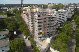  Das Wohngebäude besteht aus einem achtstöckigen sowie (dahinter) einem sechsstöckigen Komplex 