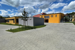 Auf der Rückseite der Gebäude wurde eine große Fläche als Parkplatz angelegt – farblich in schlichtem Grau gehalten 