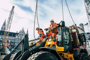 Der Radlader L120 Electric wird fachmännisch an einem der beiden Kräne am Marienhof in München befestigt