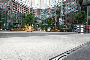  Auch das dunkle Pflaster bleibt getreu dem Motto „den Bestand durch Rekombination stärken“ erhalten, jedoch ersetzen fortan helle Granit- die ausgedienten Edelstahlplatten. Die neuen Rinnenstränge, deren Schlitzperforationen an das Muster des vorherigen Metallbelags angelehnt sind, leiten das anfallende Niederschlagswasser in einen darunter bestehenden 5 Zentimeter tiefen Hohlraum, der in die Kanalisation mündet 