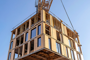  Grafikmotiv zur VDI-Konferenz: Baustelle mit Kran (Holzbau) und Text „Wie wird Bauen schneller, bezahlbarer und klimaneutral? – Jetzt lesen!“. 