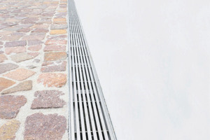  Die Längsstabroste aus Edelstahl bilden einen edlen Rahmen für die Sichtbetonfassade in der Fußgängerzone 