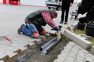  Mitarbeiter der Firma Klaus Brok Garten- und Landschaftsbau brachten die erste Rinne mit Ablaufstutzen an der Verrohrung der Entwässerung an. 