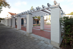  Eine mächtige, zweireihige Pergola aus geschlämmtem 2DF-Kalksandstein-Sichtmauerwerk grenzt das Grundstück zur Straße ab.  