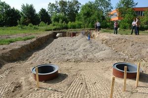  Die D-Raintanks werden nach der Montage mit Kies überdeckt. Vorne im Bild zu sehen: zwei HS-Reinigungsschächte DN/OD 800, in denen die Regenwasserzuleitungen ankommen 