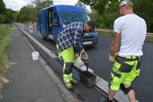  In einem Dünnbettklebeverfahren wird 2-K-Kunststoff auf der Asphaltfahrbahn aufgebracht und die Bordsteine mit der geschnittenen Seite verklebt.  