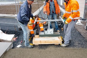  Die Grauwacke-Platten werden in die Haftschlämme eingetaucht und dann auf dem Bettungsmörtel verlegt 