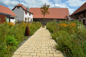  Der natürliche Pflasterbelag Via Natura im Farbton sandgelb texturiert schmückt auch den Kräutergarten des Hofgutes.  