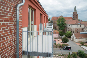  Die Denkmalschutzbehörde stimmte zu, die wieder aufgebaute Fassade des Mittelteils der Burgmühle zu verputzen anstatt zu verklinkern. Das Rot ist auf die sanierte Ziegelfassade abgestimmt. Der Anbau der Balkone ist ebenfalls ein denkmalpflegerischer Kompromiss, um zeitgemäße Wohnqualität in der alten Mühle zu ermöglichen.
 